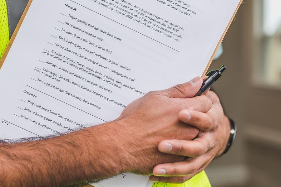 Inspector completing a checklist on a clipboard